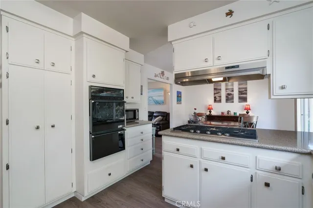 a kitchen with white cabinets and appliances