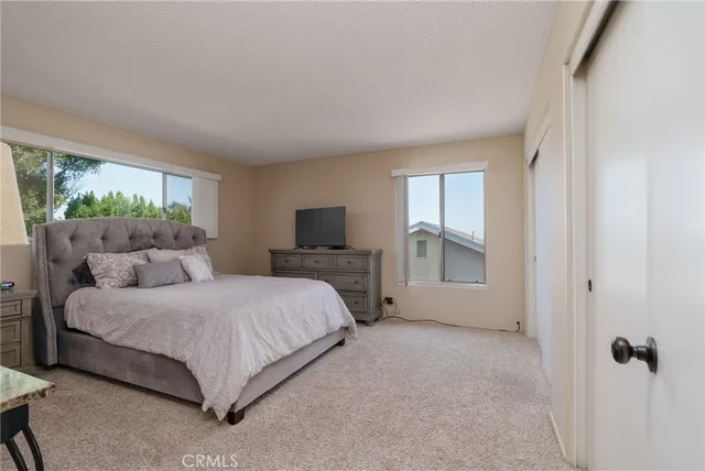 a bedroom with a bed and a large window