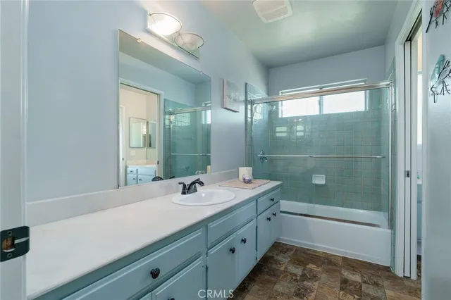 a bathroom with a sink double vanity granite tub shower and a mirror