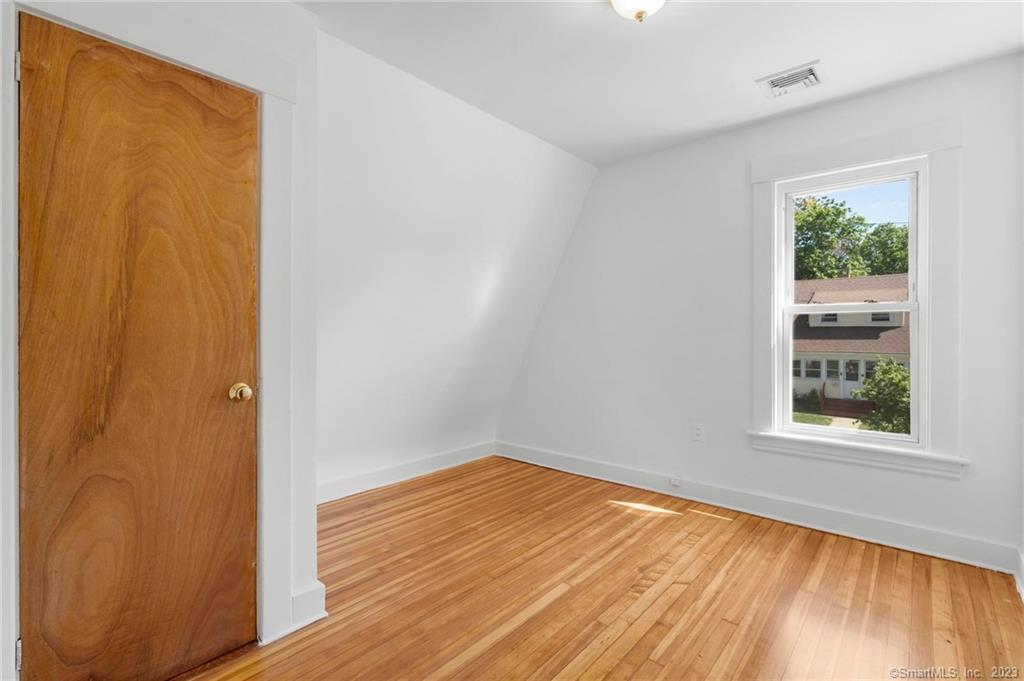 22 Sycamore Lane Waterbury, CT 06705 - Photo 28 of 31 an empty room with wooden floor and windows