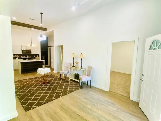 a living room with stainless steel appliances kitchen island granite countertop furniture and a rug