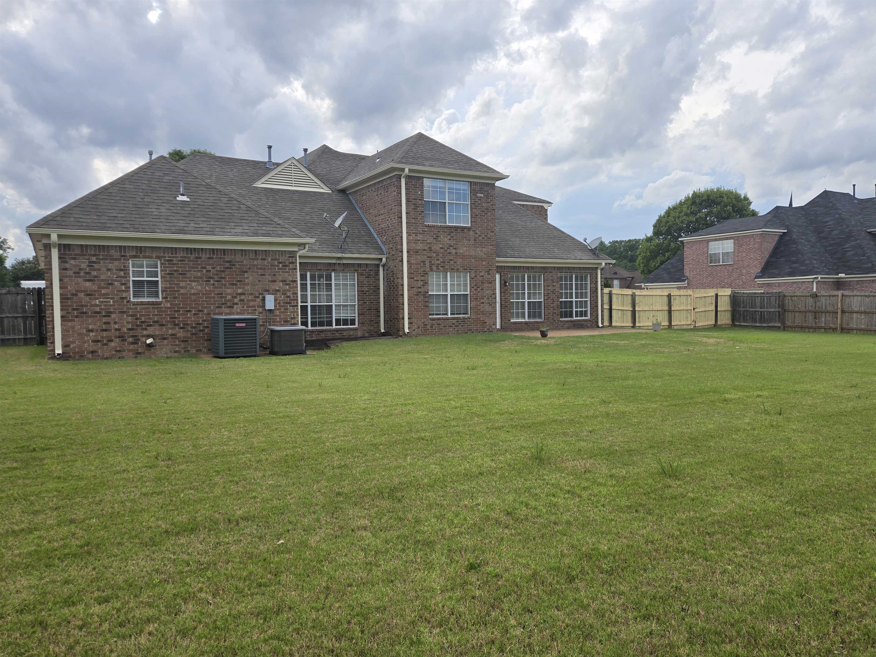 5186 Guffin Road Bartlett, TN 38135 - Photo 20 of 21 Rear view of property featuring brick siding, a fenced backyard, and a shingled roof