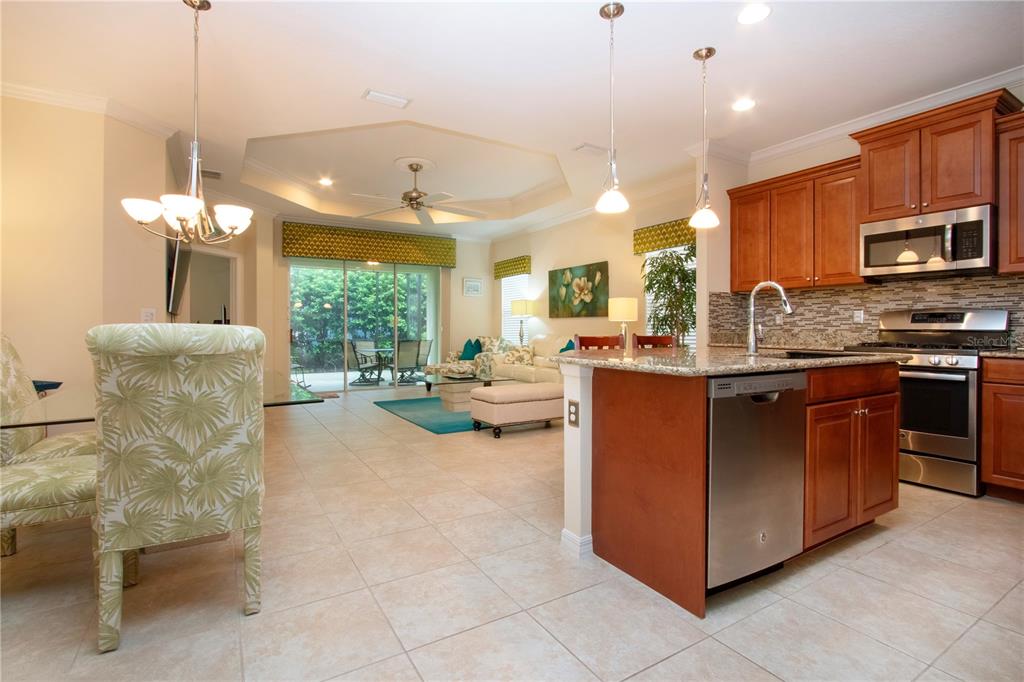 4920 Maymont Park Circle Bradenton, FL 34203 - Photo 14 of 59 a kitchen with stainless steel appliances granite countertop a stove and a view of living room