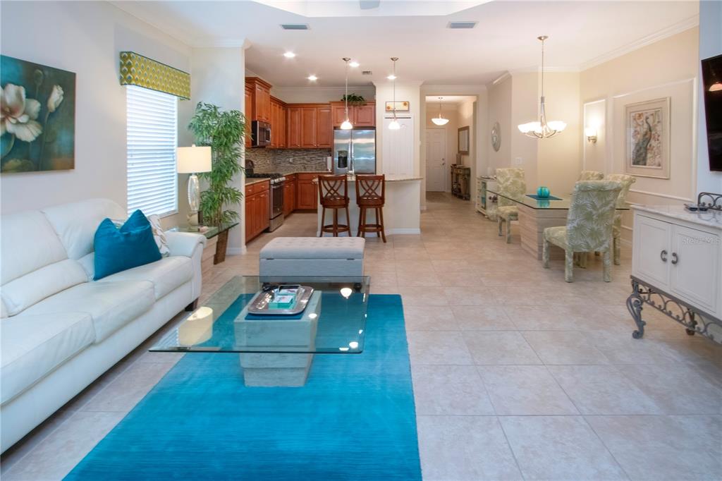 4920 Maymont Park Circle Bradenton, FL 34203 - Photo 27 of 59 a living room with furniture and a dining table with kitchen view