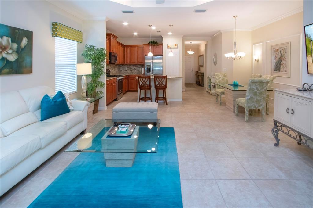 4920 Maymont Park Circle Bradenton, FL 34203 - Photo 28 of 59 a living room with furniture and a dining table with kitchen view