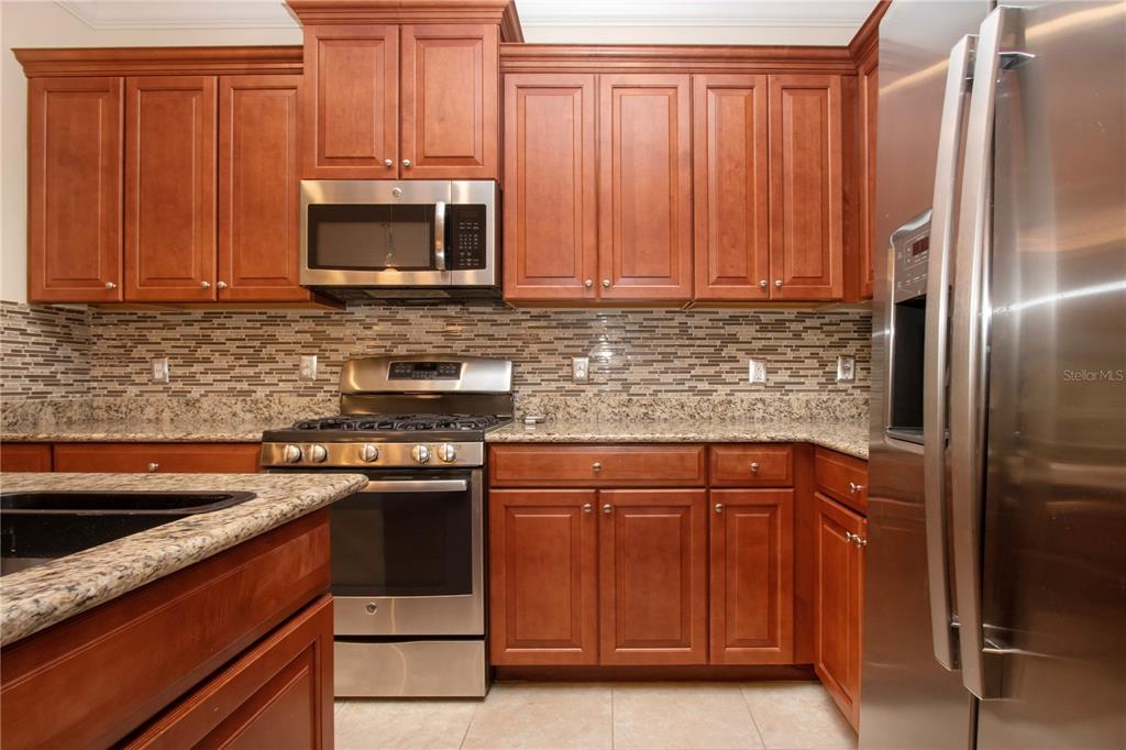 4920 Maymont Park Circle Bradenton, FL 34203 - Photo 32 of 59 a kitchen with stainless steel appliances granite countertop a stove a refrigerator and a sink