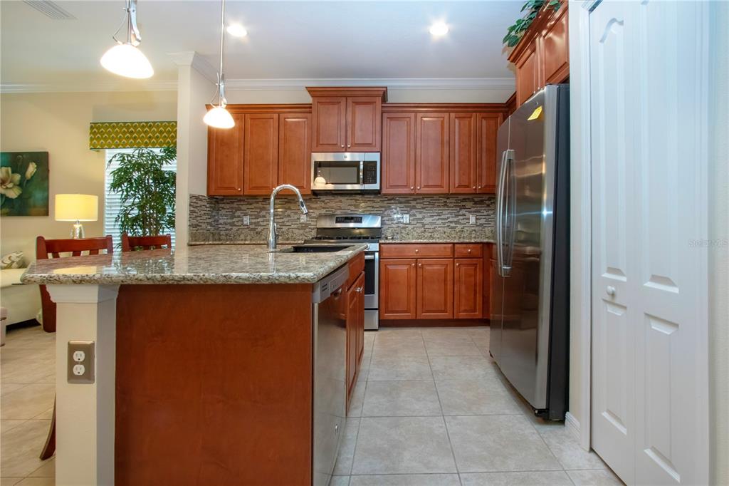 4920 Maymont Park Circle Bradenton, FL 34203 - Photo 34 of 59 a kitchen with stainless steel appliances granite countertop wooden cabinets a sink a stove a refrigerator and a oven