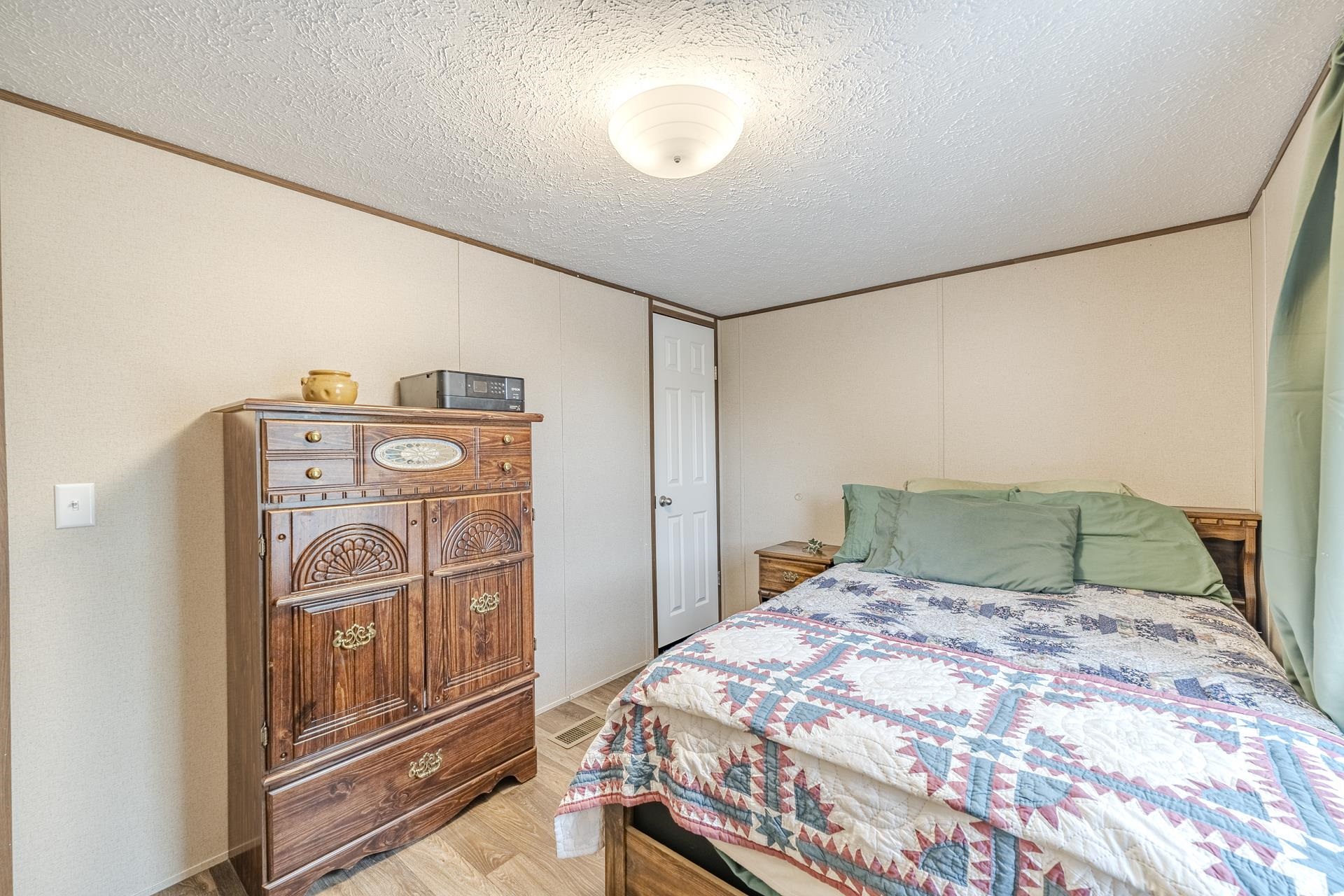 3275 Glendale Road Adamsville, TN 38310 - Photo 29 of 39 a bedroom with a large bed and a chandelier