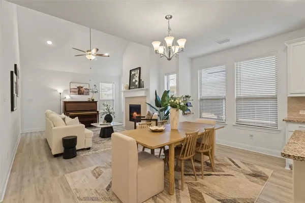 a view of a dining room with furniture a chandelier and wooden floor