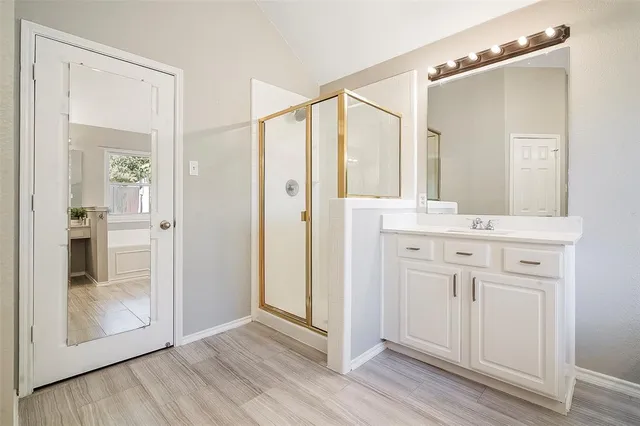 a bathroom with a double vanity sink toilet mirror and shower