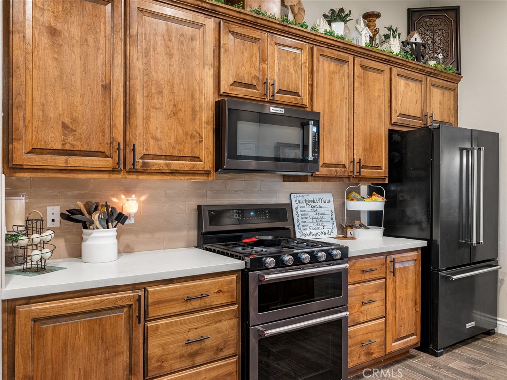 15620 Erie Road Apple Valley, CA 92307 - Photo 16 of 53 a kitchen with granite countertop a refrigerator stove and microwave