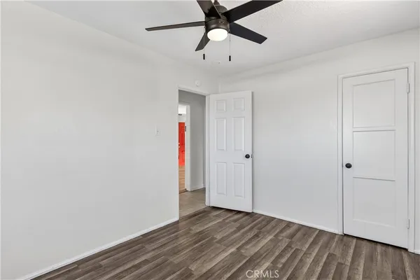 an empty room with a window and a ceiling fan