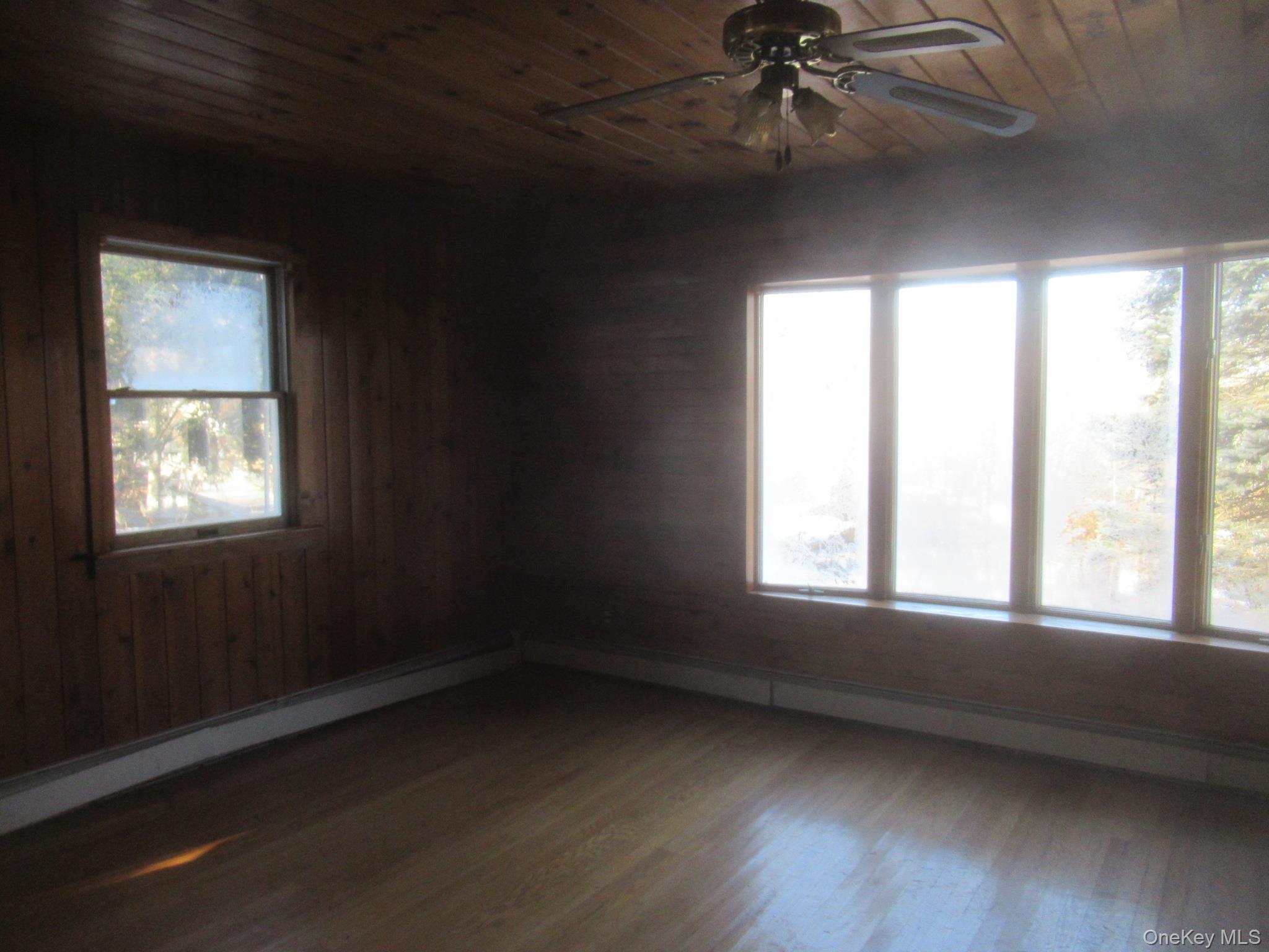 270 Bucks Hollow Road Mahopac, NY 10541 - Photo 6 of 11 Living room with wood ceiling, ceiling fan, dark wood-type flooring, and baseboard heating
