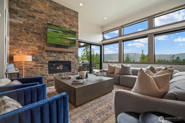 a living room with furniture fireplace and a large window