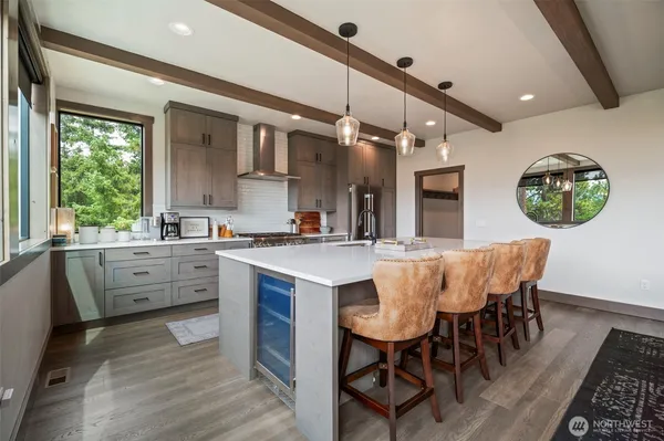 a kitchen with stainless steel appliances kitchen island granite countertop a table chairs sink and cabinets