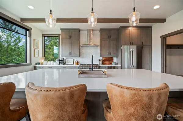 a living room with stainless steel appliances granite countertop a couch and a chandelier