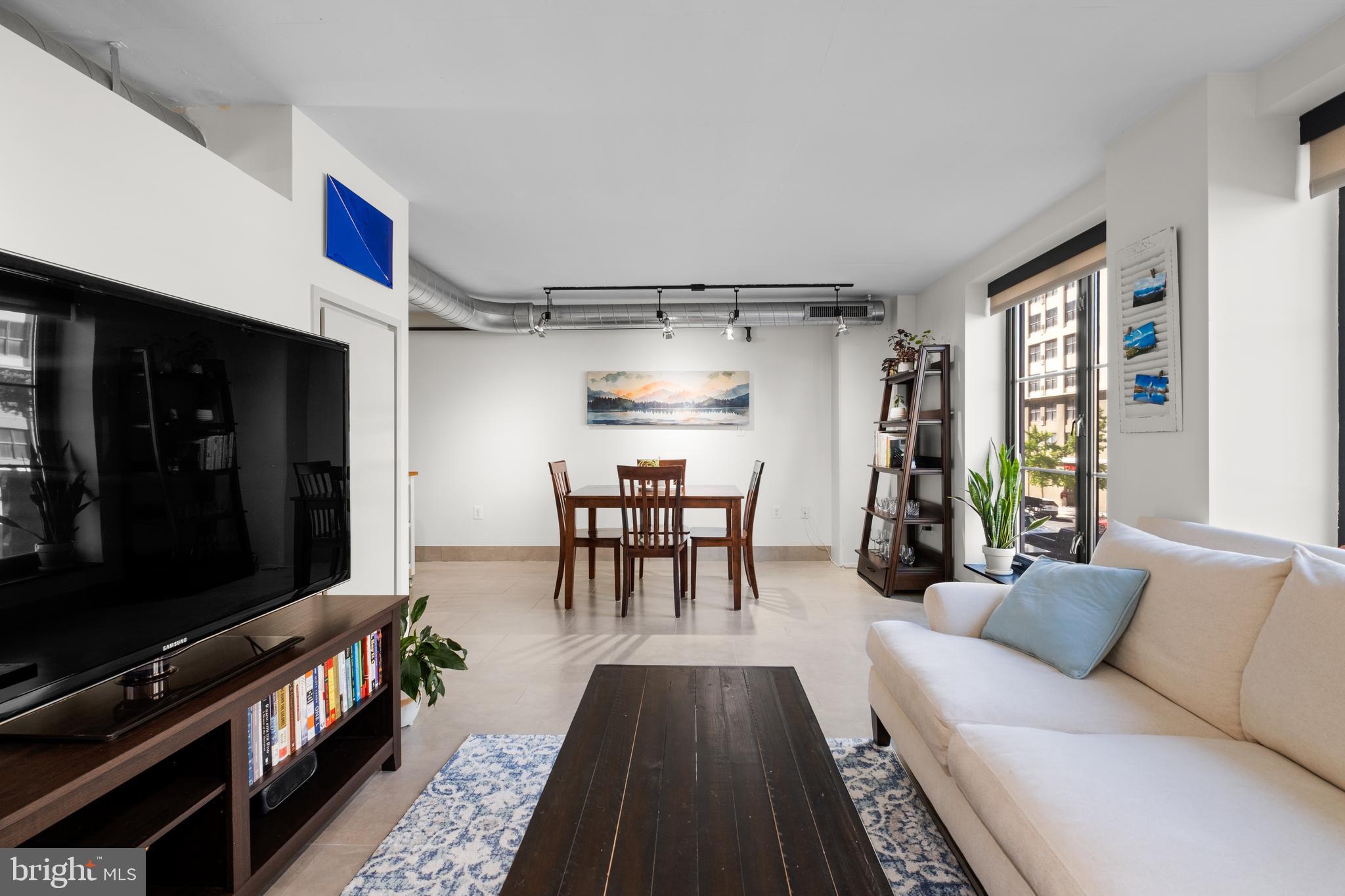 1133 14th Street Northwest, Unit 210 Washington, DC 20005 - Photo 5 of 34 a living room with furniture and a flat screen tv