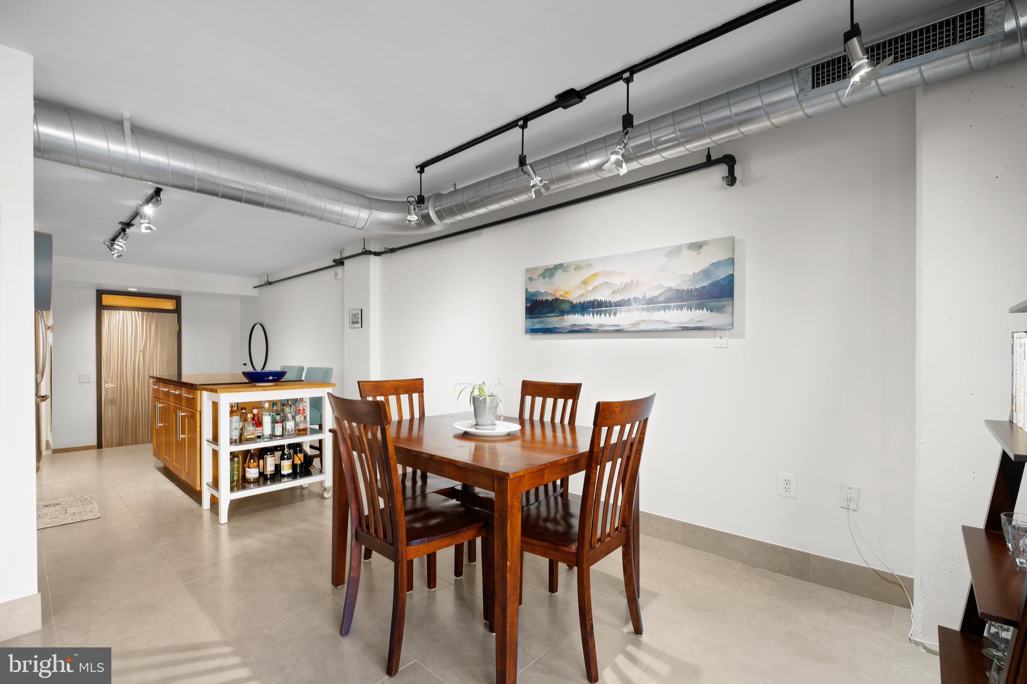 1133 14th Street Northwest, Unit 210 Washington, DC 20005 - Photo 8 of 34 a dining room with a wooden table and chairs