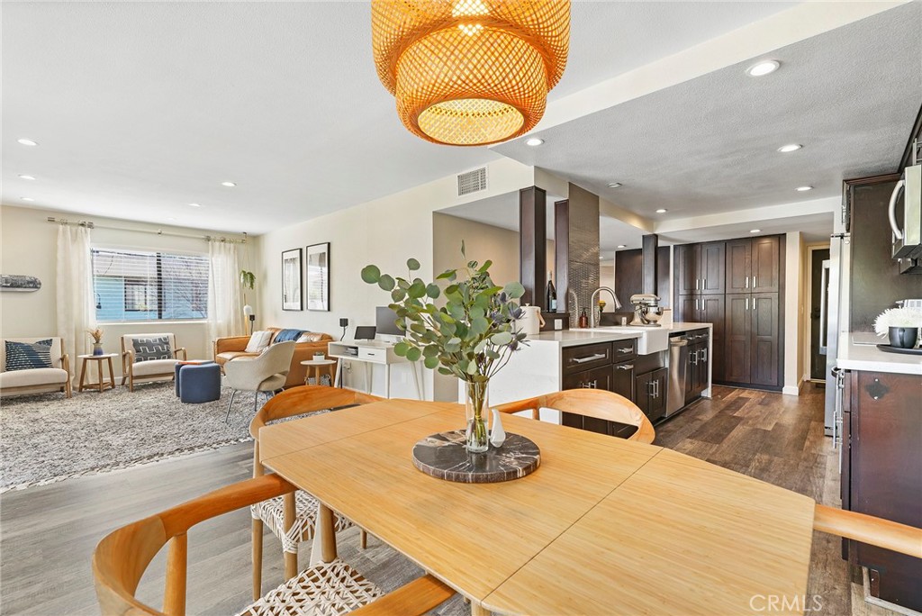 2135 East 4th Street, Unit 202 Long Beach, CA 90814 - Photo 6 of 23 a kitchen with stainless steel appliances kitchen island granite countertop a table and chairs in it