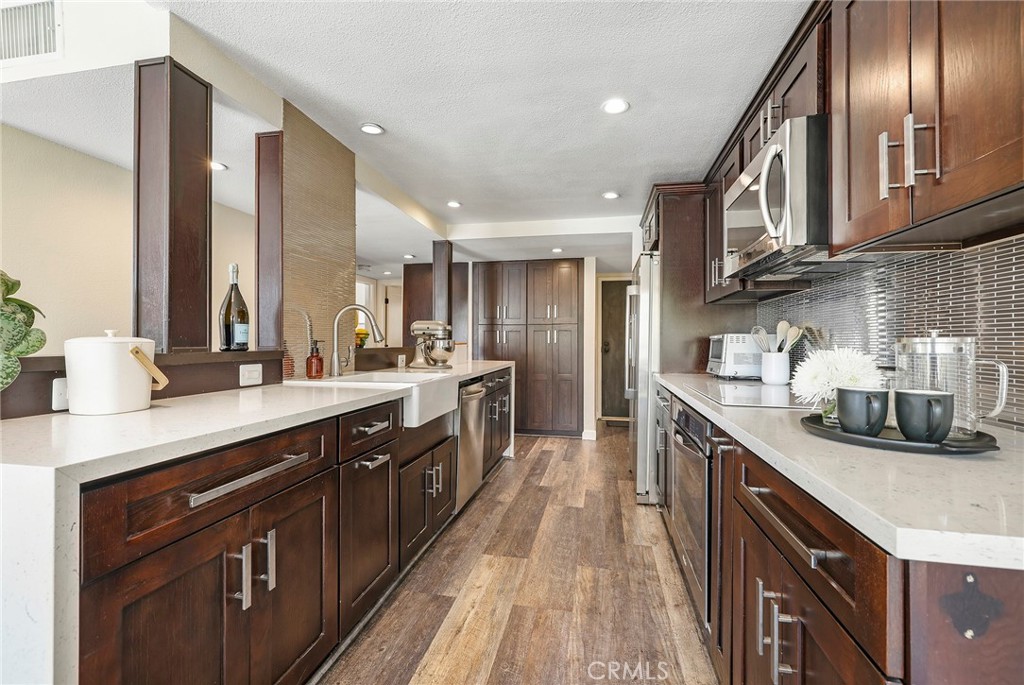 2135 East 4th Street, Unit 202 Long Beach, CA 90814 - Photo 7 of 23 a kitchen with stainless steel appliances granite countertop a sink a stove and a wooden cabinets