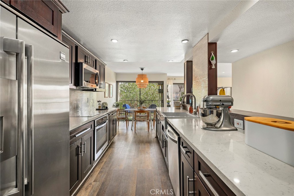 2135 East 4th Street, Unit 202 Long Beach, CA 90814 - Photo 8 of 23 a kitchen with sink cabinets and stainless steel appliances