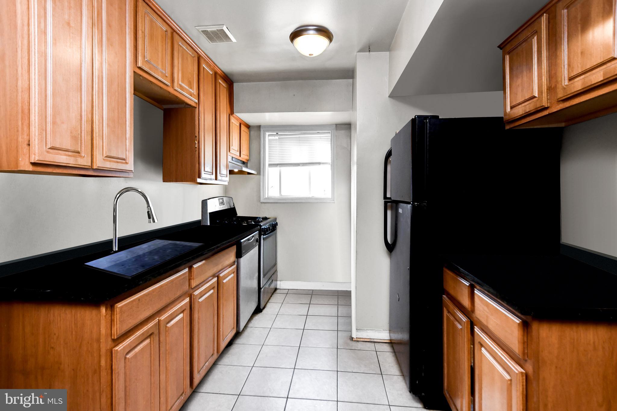 5009 D Street Southeast, Unit 202 Washington, DC 20019 - Photo 6 of 12 a kitchen with stainless steel appliances granite countertop a sink a stove and a refrigerator