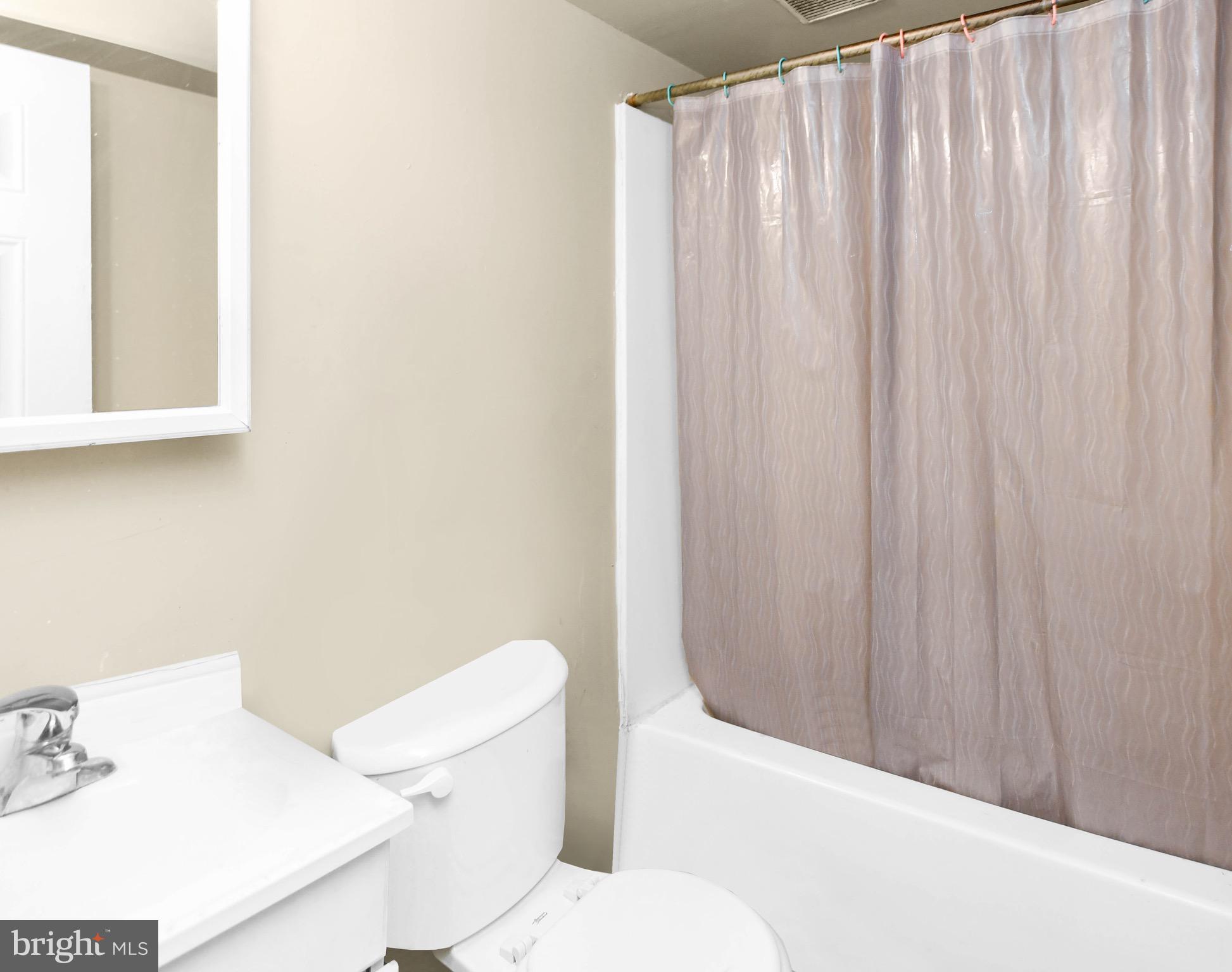 5009 D Street Southeast, Unit 202 Washington, DC 20019 - Photo 8 of 12 a bathroom with a sink a toilet and shower curtain