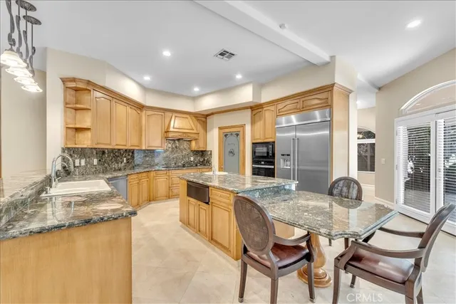 a dining hall with stainless steel appliances granite countertop a sink a counter space and living room view