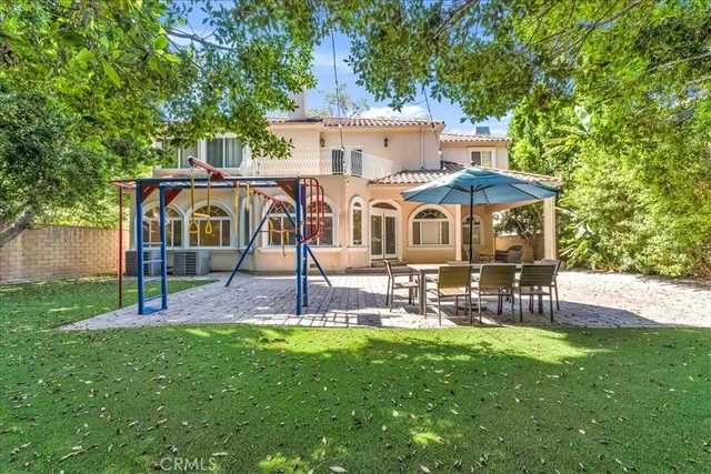 a view of a house with backyard and sitting area