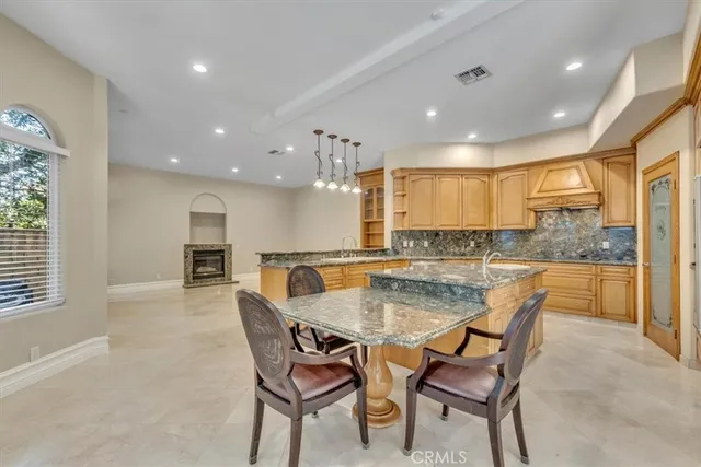 a large kitchen with kitchen island granite countertop a sink and a stove top oven