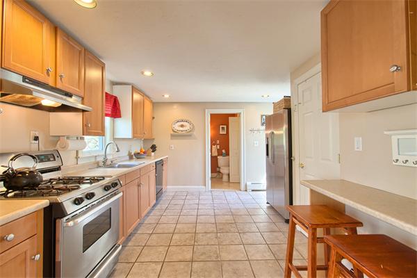 48 Spring Street Stoneham, MA 02180 - Photo 8 of 29 a kitchen with stainless steel appliances granite countertop a stove a sink and a refrigerator
