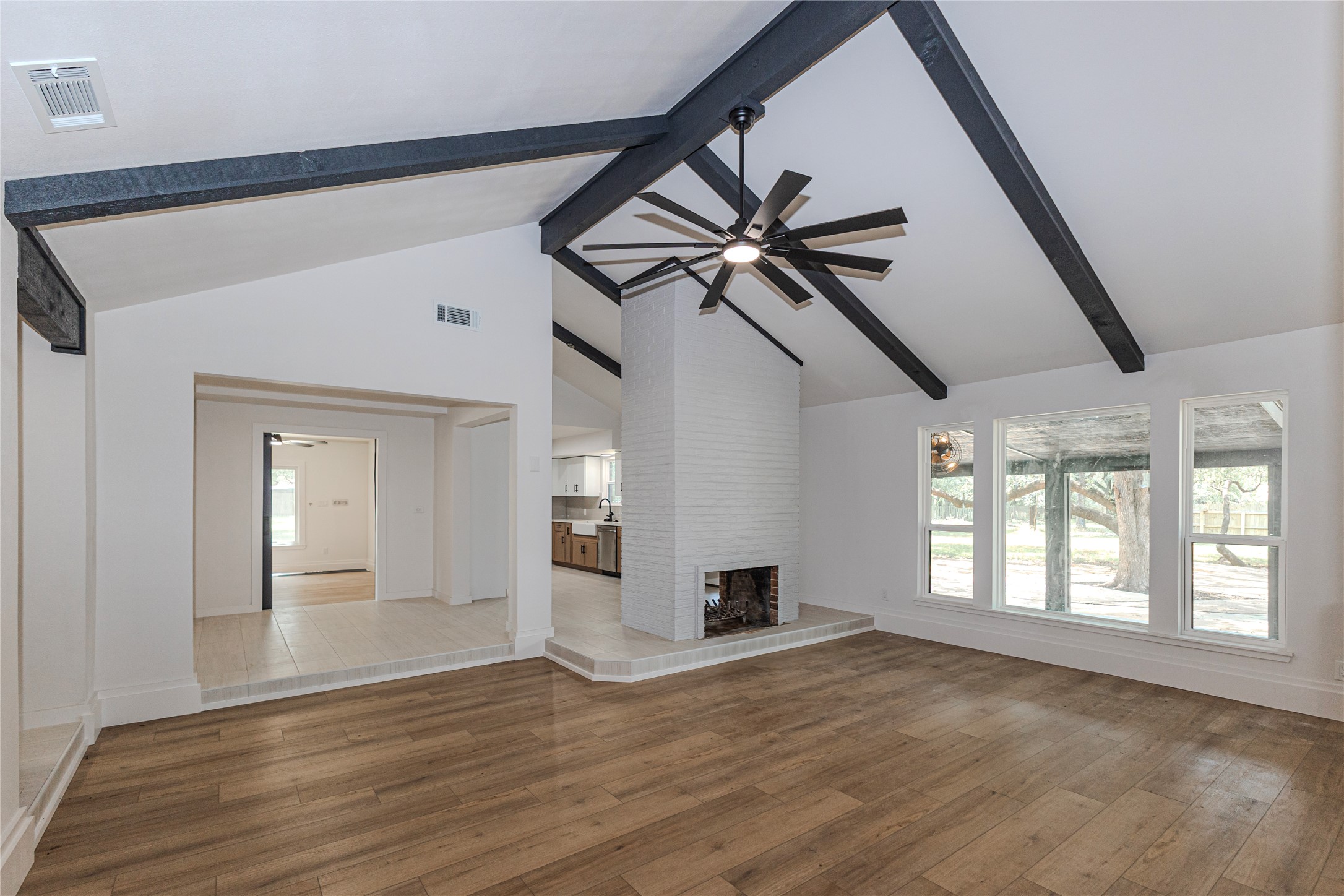 205 Bello Circle Georgetown, TX 78628 - Photo 32 of 36 A striking fireplace grounds this spacious living area, highlighted by vaulted ceilings and a modern fan.