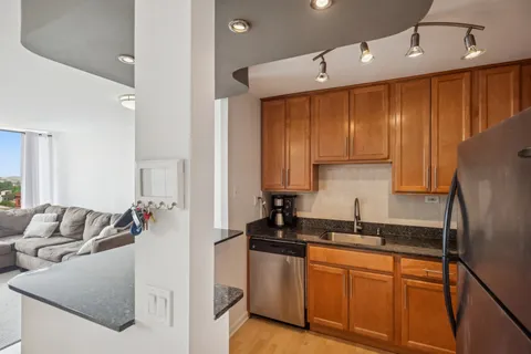 a kitchen with granite countertop a sink stainless steel appliances and cabinets