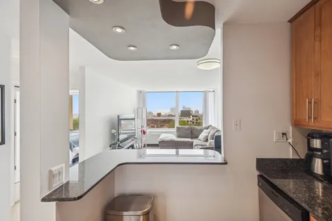 a kitchen with stainless steel appliances granite countertop a refrigerator a sink and white cabinets