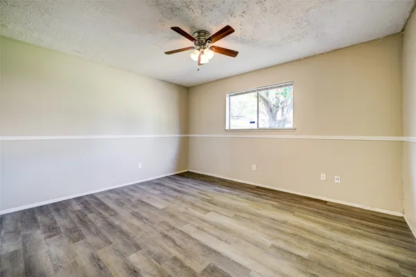 an empty room with ceiling fan and window