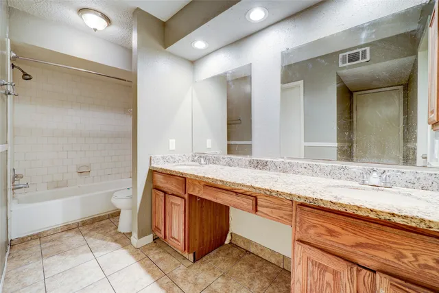 a bathroom with a granite countertop sink mirror and bathtub