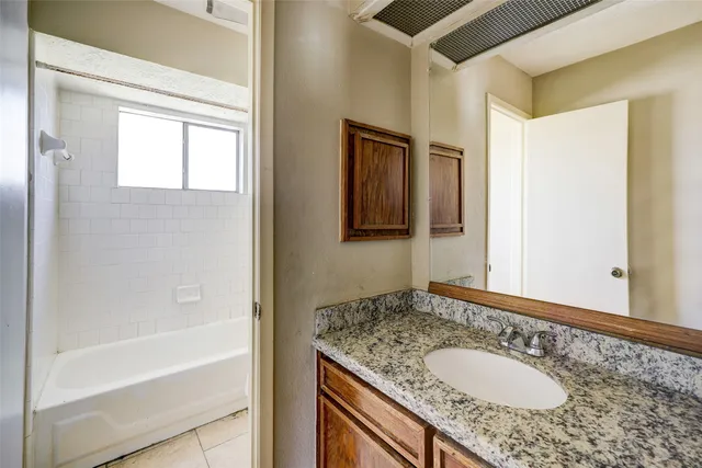a bathroom with a granite countertop sink and a mirror