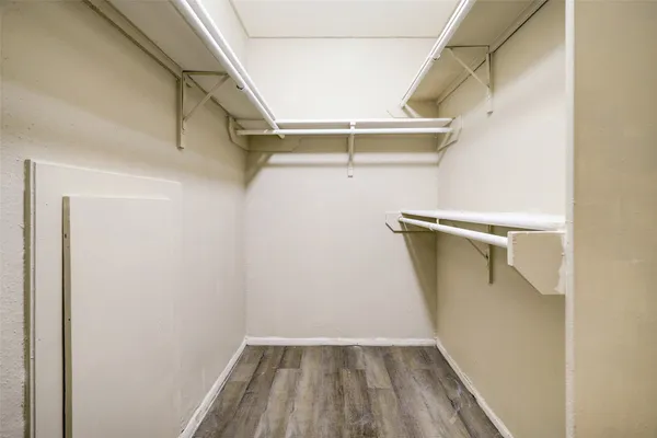 a view of walk in closet with empty racks