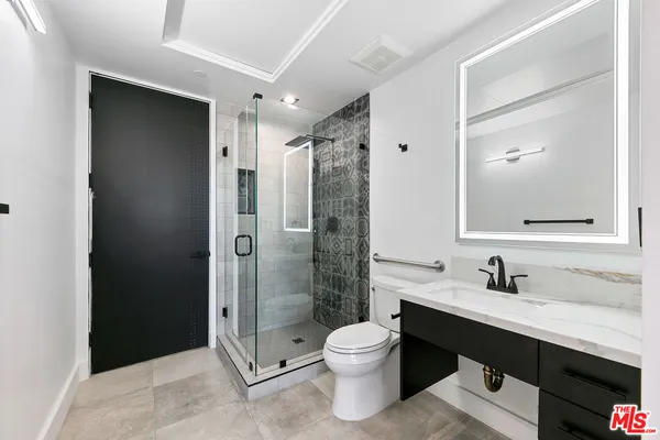 a bathroom with a double vanity sink toilet and shower