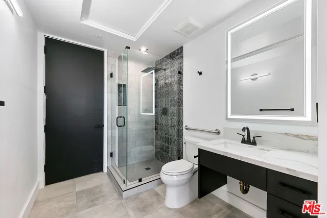a bathroom with a double vanity sink toilet and shower