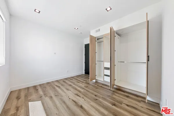 a view of a room with wooden floor and a bathroom
