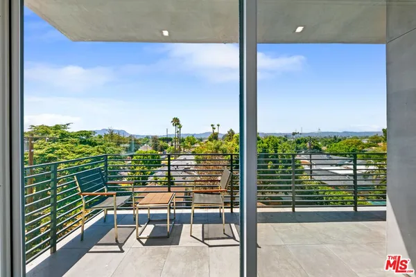 a view of a balcony with floor to ceiling windows with wooden floor