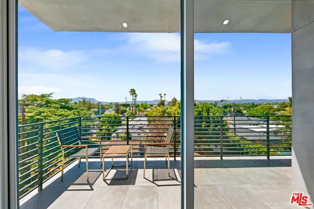 a view of a balcony with floor to ceiling windows with wooden floor