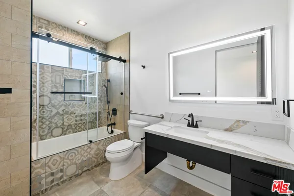 a bathroom with a sink a toilet and shower