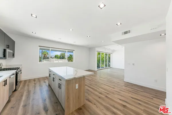 a spacious bathroom with a granite countertop sink a window and a mirror