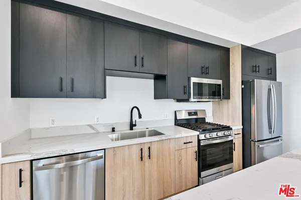a kitchen with stainless steel appliances a sink cabinets and a refrigerator