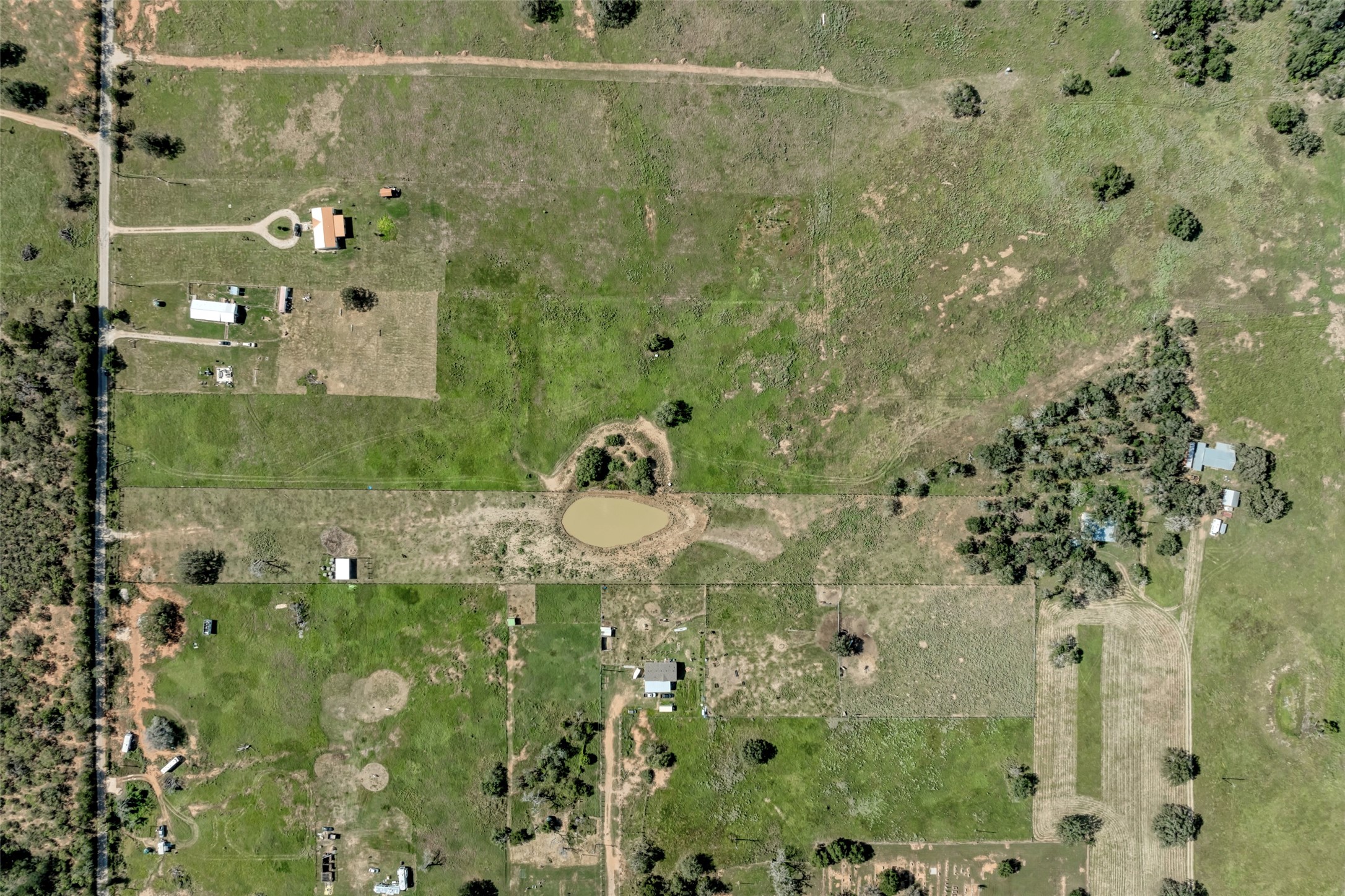5309 Tenney Creek Road Luling, TX 78648 - Photo 17 of 23 An aerial perspective reveals sprawling, verdant land with a serene pond and multiple structures, perfect for a rural estate.