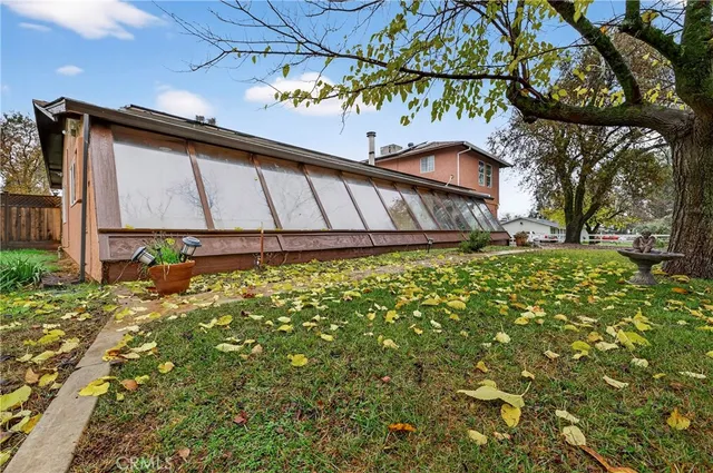 a view of a house with a yard and large tree