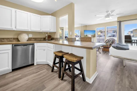 a kitchen with stainless steel appliances granite countertop a table chairs sink and cabinets