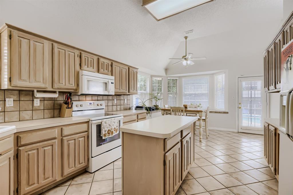 1413 West Peters Colony Road Carrollton, TX 75007 - Photo 11 of 29 a kitchen with stainless steel appliances granite countertop a sink a stove a refrigerator and cabinets
